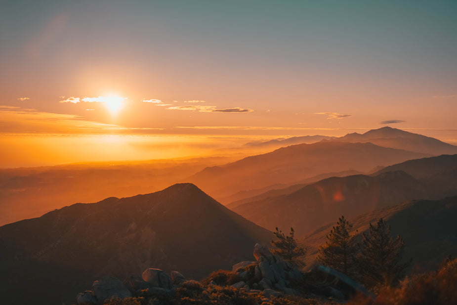 foggy mountains with sun setting behind them